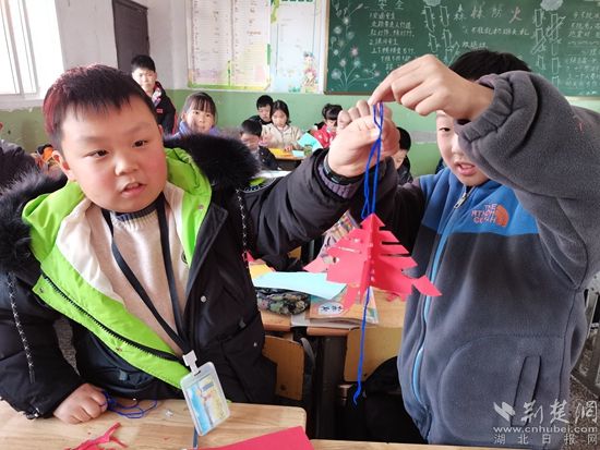 孩子们在展示自己的剪纸作品。.jpg.jpg
