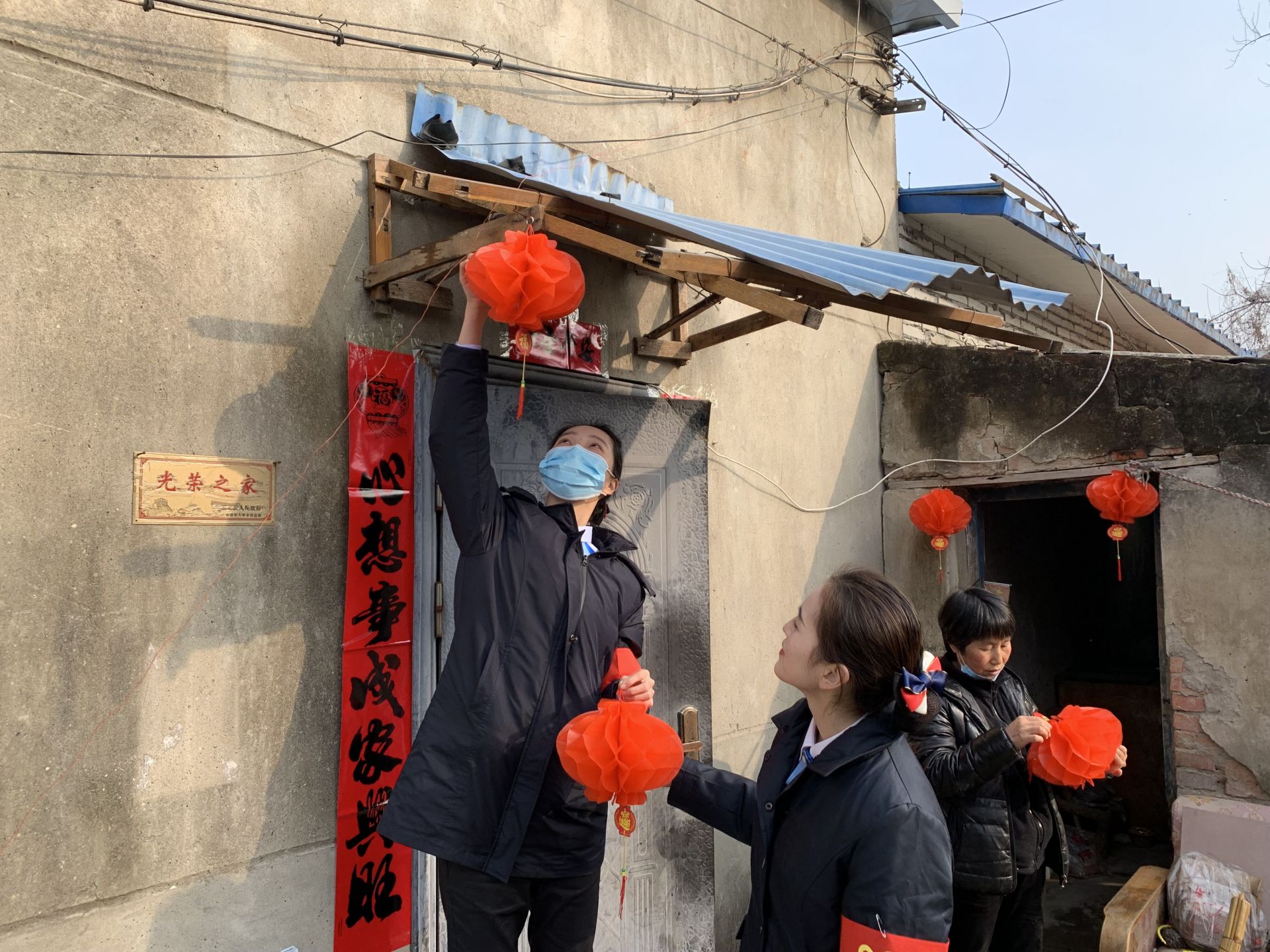 志愿者为老人家门口挂上火红灯笼 刘珍珍 摄.jpg.jpg