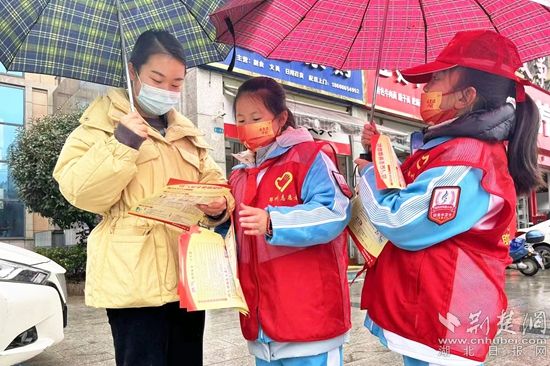 市实验小学小宣讲员打着雨伞在大街宣传安全知识_副本.jpg.jpg