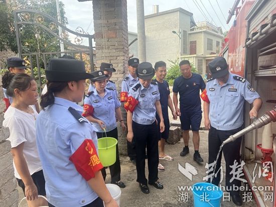 民辅警跟随消防水车作业，通过肩挑手提的方式将清水送入行动不便的老年、残障村民的家中（通讯员 李丽君 摄） (3).jpg.jpg