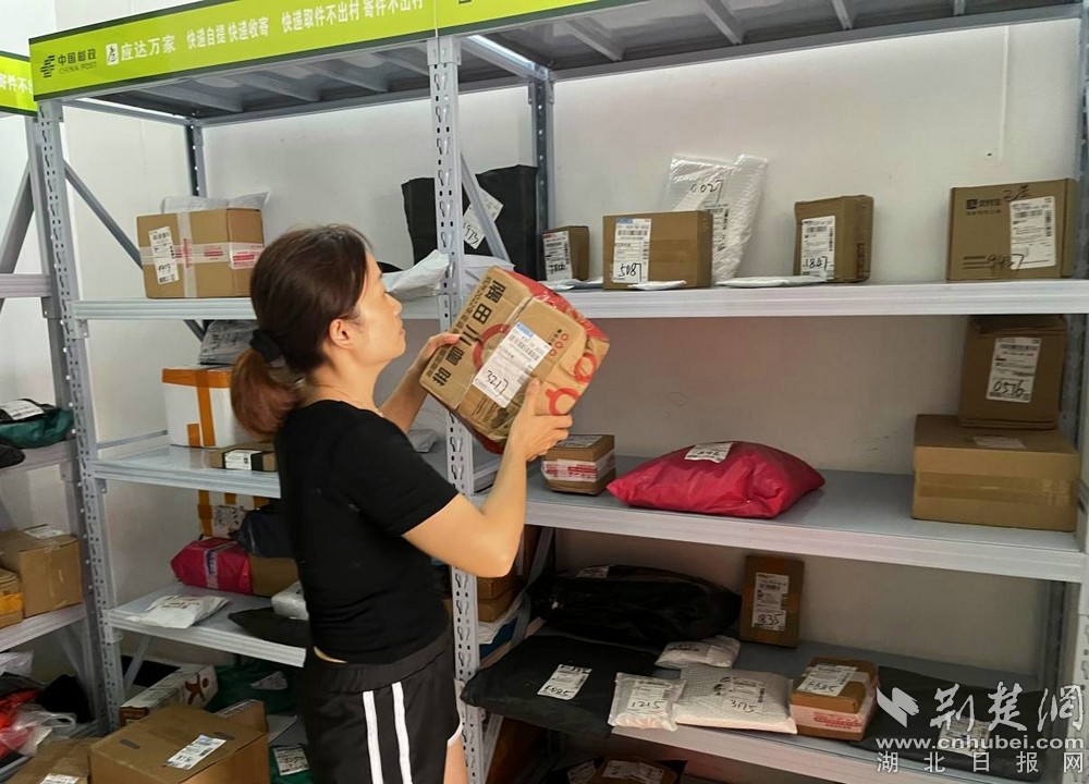 在城北街道西十村寄递物流综合便民服务站,站点负责人正在对快递包裹进行分类摆放 摄 余新怡摄.jpg