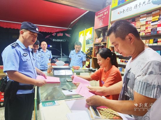 图为崇阳县公安局青山派出所民警辅警在辖区沿街商铺开展反诈宣传.jpg.jpg