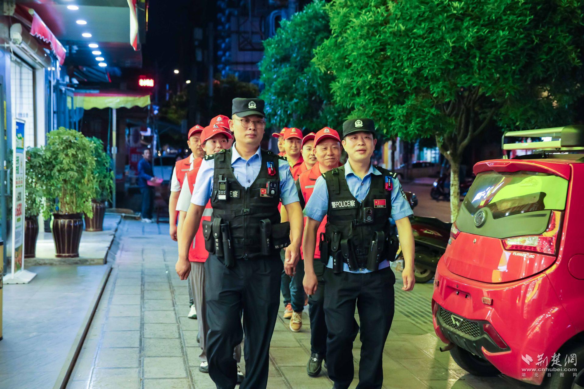 红岩派出所民辅警组织红马甲平安义警队在集镇开展夜间巡逻。.jpg.jpg