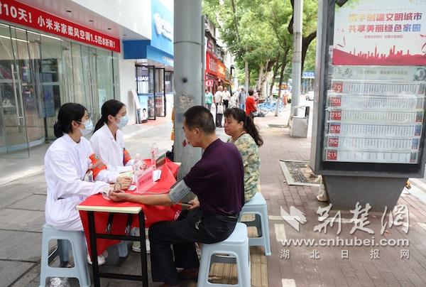 在途经的公交站，武汉市中心医院设置“健康驿站”为等候乘车的市民免费提供测血压等健康服务.JPG