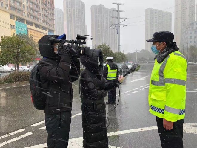 孝感市融媒体中心杨亚玲（风雪中，采访疫情期间重返一线的退休警察）_副本.jpg.jpg