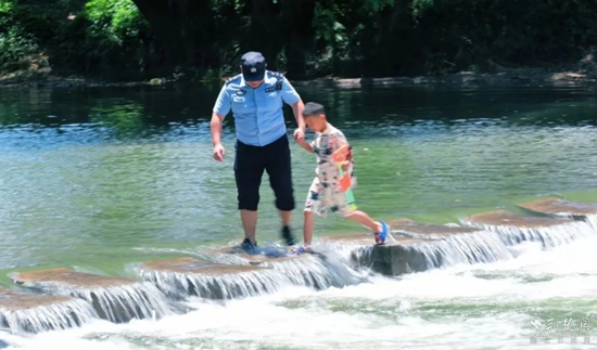 马桥派出所民警牵着在河中玩水的孩子返回岸边.jpg