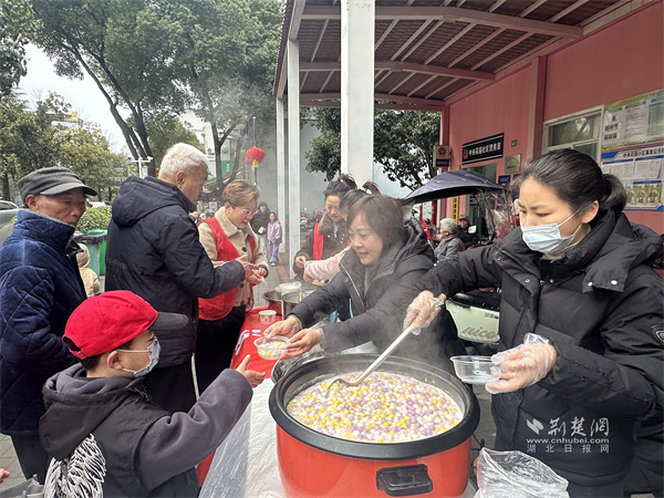 志愿者们将软糯香甜的元宵递到居民手里.jpg