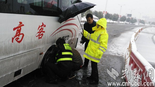 图一：暴雪来袭，总有温情在路上。图为汉十张湾所工作人员为受困司乘安装防滑链。闫丽 摄.jpg