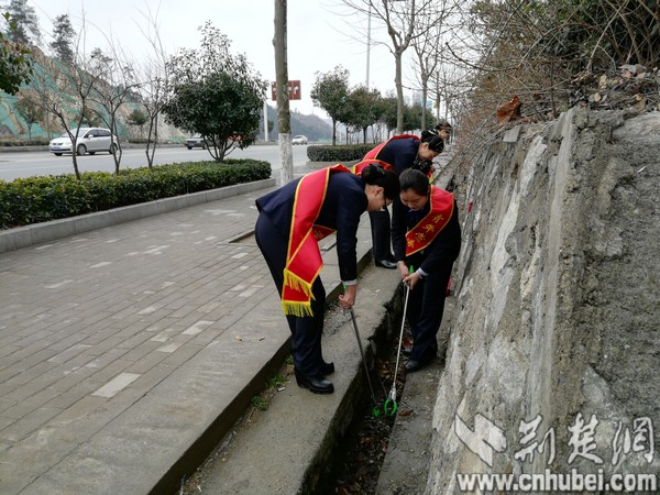 志愿者发扬不怕脏、不怕苦的精神，在沟渠清洁垃圾。（闫丽 摄）.jpg