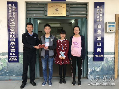 图为民警将打印好的户口簿递给姐弟俩。郧阳区公安分局白桑所 供图.jpg
