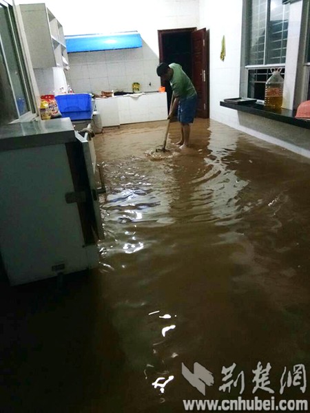 姚河小学徐丰奎老师在排完水后，清除地面泥浆 副本.jpg