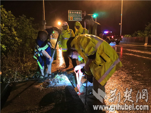 养护防汛应急人员正在疏通凉水井隧道路面排水沟.jpg