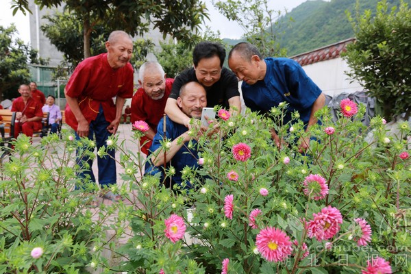 赵耀成和老人们一起拍花.JPG
