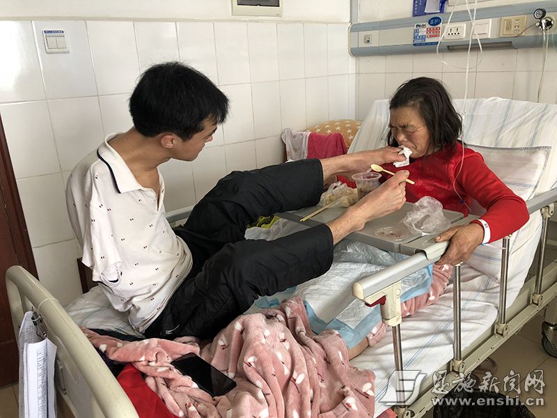 陈兹方用双脚给母亲喂饭吃。