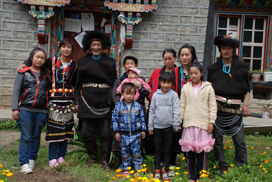 图为 娅米一家的幸福照(左起为:娅米小妹米玛卓玛、娅米、外公达果、外婆娅加和小侄儿达嘎、大嫂扎西、大妹娅英、大哥达玛;前排为娅米的两个侄女和大侄儿)。记者 麦正伟 摄