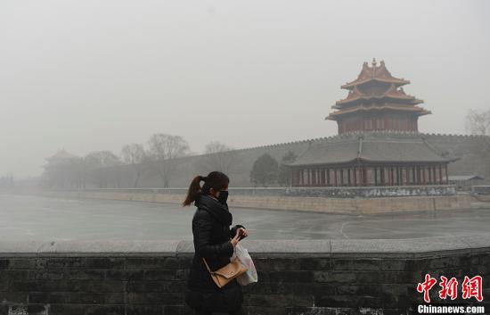 1月13日,北京天安门广场区域许多游客带上白色口罩严防空气污染。廖攀 摄