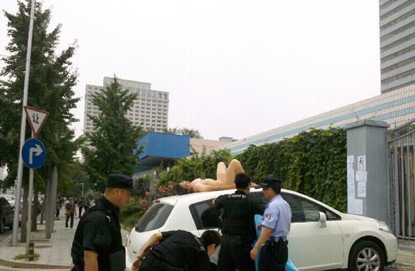 女子裸体躺在中央电视台门前车顶 被安保人员控制(图)